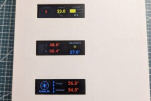 Pellet-Heizungs-Cockpit: drei leuchtende Displays zeigen Lagerstand, Temperaturen und Solarwert